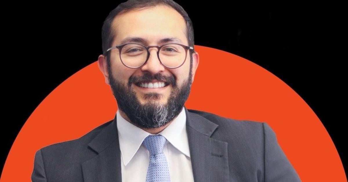 carlos alberto suarez , foto de un señor mirando a la cámara con un fondo naranja y negro