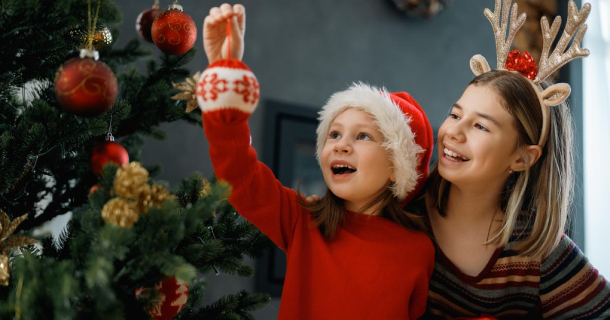 Foto de dos mujeres colgado items en el árbol de navidad
