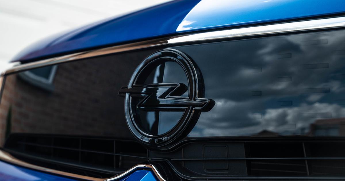 Foto de una camioneta azul con el logo de Opel