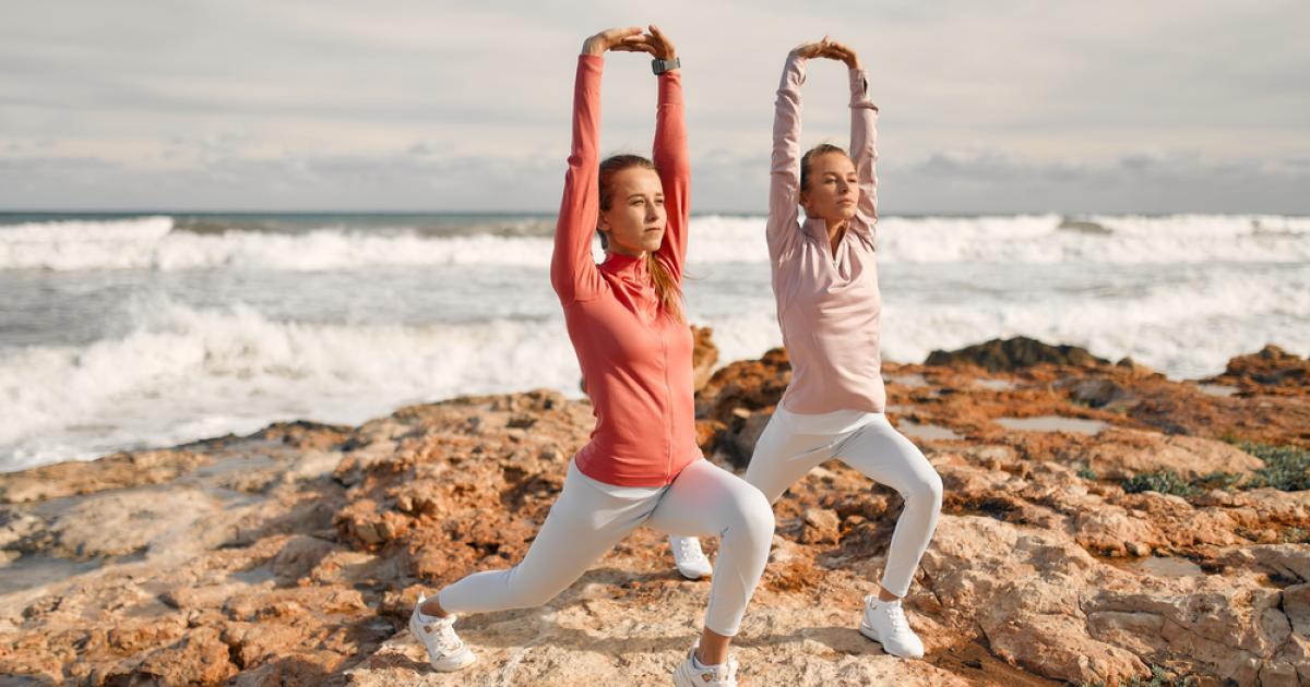 Dos mujeres haciendo deportes con la playa de fondo