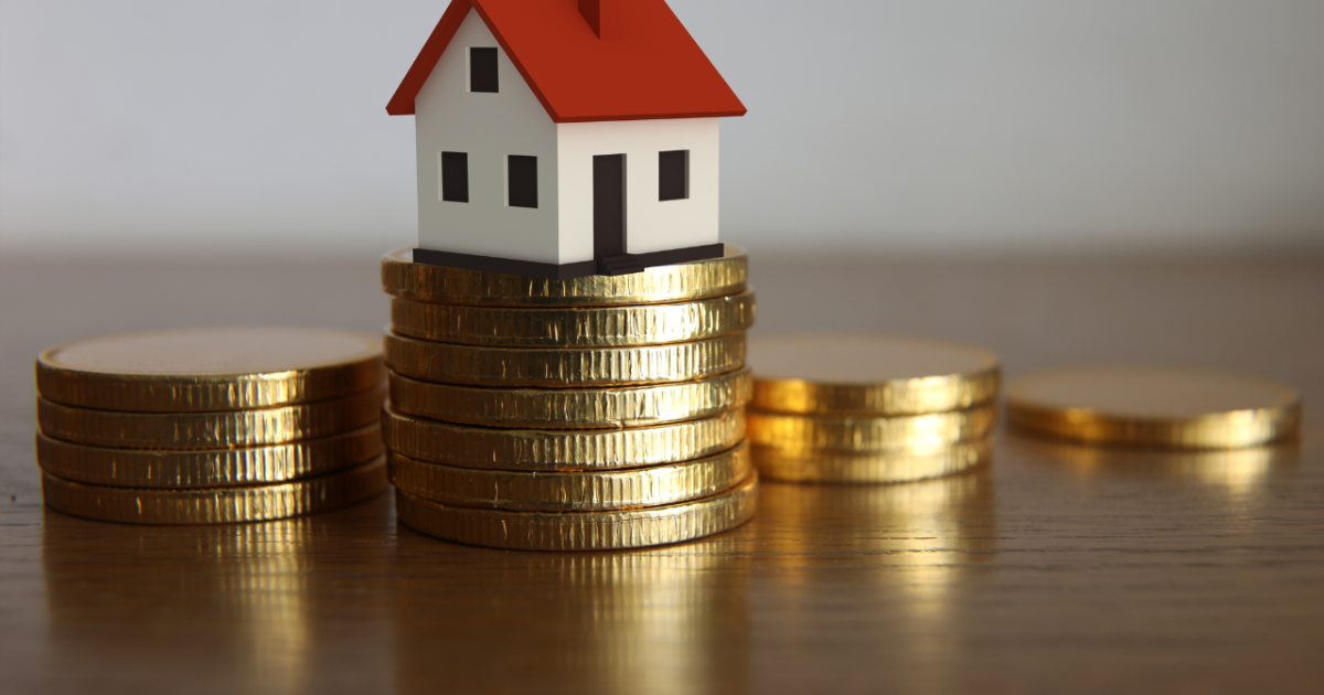 monedas y una casa pequeña