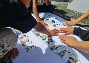 Imagen de niños juntando sus manos en una cartulina