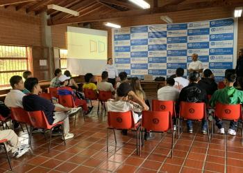 salon con niños sentados y una persona de pie presentando