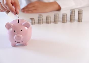 Marrano de ahorro con monedas de fondo