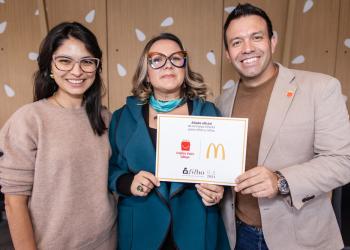 Foto de tres personas, dos mujeres y un hombre posando para la cámara