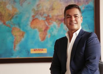 foto de un señor sonriendo a la cámara con un mapa de fondo