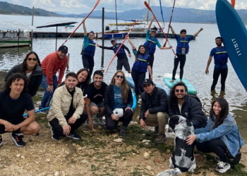 Foto devarias personas reunidas y mirando a la cámara con un lago de fondo