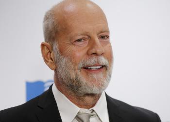 Foto de bruce willis, un señor con barba en traje y fondo blanco