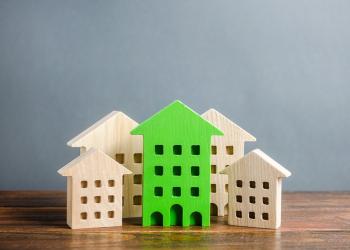 Foto de cinco casas de madera y una de ellas está pintada de verde