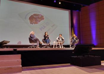 Foto de cuatro mujeres sentadas frente a un panel