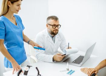 Foto de dos médicos mirando a un computador