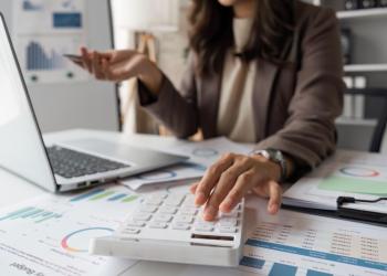 Foto de la mano de una mujer cuadrando las finanzas de una compañía