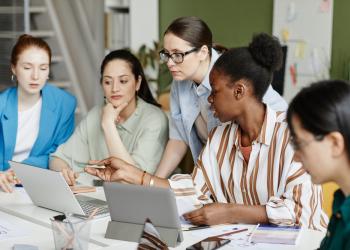 Foto de mujeres reunidas mirando un computador