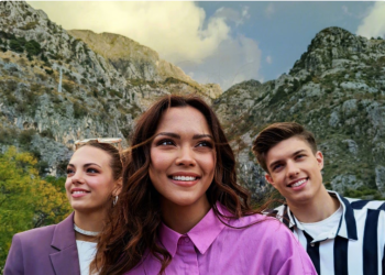 Foto de tres personas mirando a la cámara con una montaña de espaldas