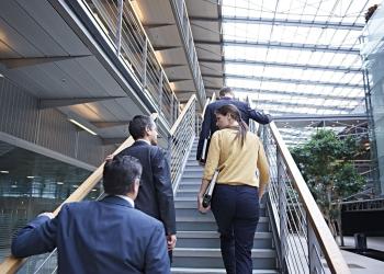 Foto de tres personas subiendo una escalera