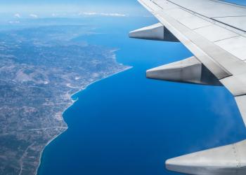 Foto de un ala de un avión y debajo la tierra y el mar