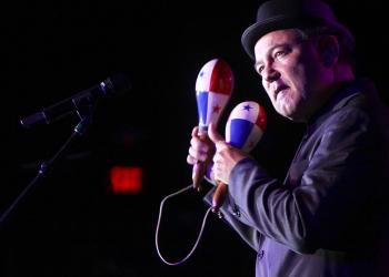 Foto de un artista con dos maracas en la mano