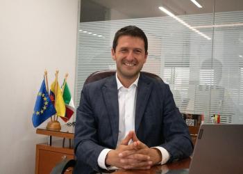 Foto de un dilomático jóven sentado mirando a la cámara