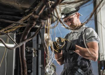 Foto de un electricista trabando con cables en sus manos