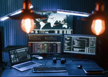 Foto de un escritorio oscuro con tres computadores