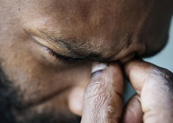 Foto de un hombre cogiendose los ojos, seña de que está estresado