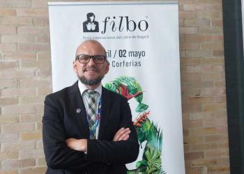 Foto de un hombre cruzado de brasil con barba y gafas negras mirando a la cámara