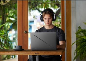 Foto de un hombre jóven y serio mirando un computador de Asus