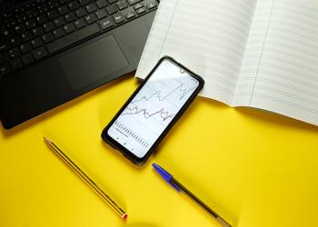 Foto de una mesa con un celular con una gráfica en su pantalla