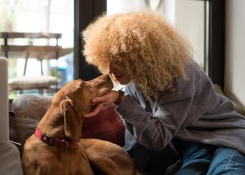Foto de una mujer acariciando un perro