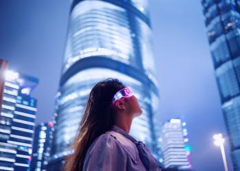 Foto de una mujer con gafas tecnológicas y un fondo de ciudad