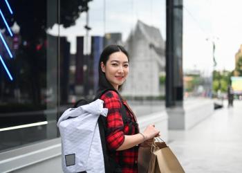 Foto de una mujer con unas bolsas en la calle