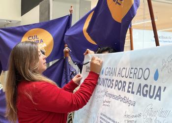 Foto de una mujer firmando un acuerdo con la mano