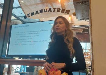 Foto de una mujer presentando frente a un televisor