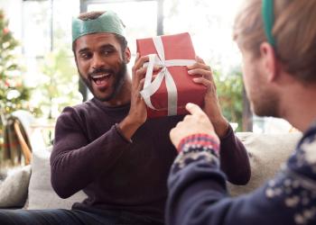 Foto de una mujer regalandole un detalle a un hombre