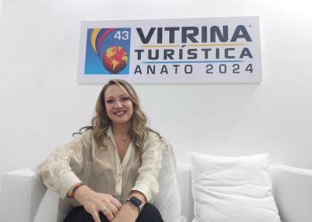 Foto de una mujer sentada en un colchón con fondo blanco mirando a la cámara