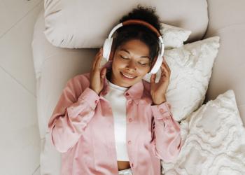 Foto de una mujer tocandose los oidos mientras escucha música