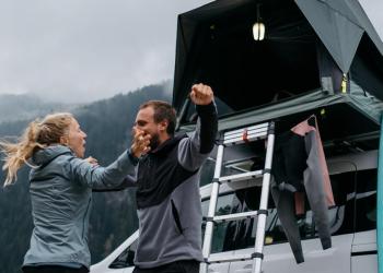 Foto de una pareja acampando con una carpa plegable de fondo