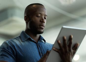 Foto de una persona afro con una tablet en la mano