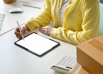 Foto de una persona con una tablet en la mesa