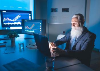 Foto de una persona mayor sentada frente a un computador