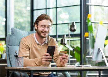 Foto de una persona mirando un celular con un fondo empresarial