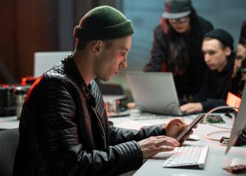 Foto de una persona simulando ser un delincuente digital