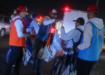 Foto de varias personas entregando kits en la calle