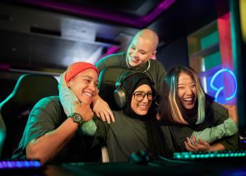 Foto de varias personas jóvenes jugando frente a un pc