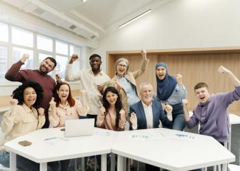Foto de varias personas levantando la mano y sonriendo a la cámara