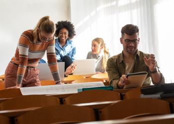 Foto de varias personas sentadas en una mesa mirando a la cámara, pruebas saber pro