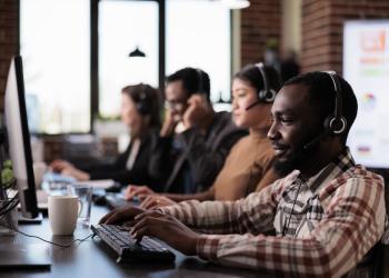 Foto de varias personas trabajando en una emrpesa frente al computador