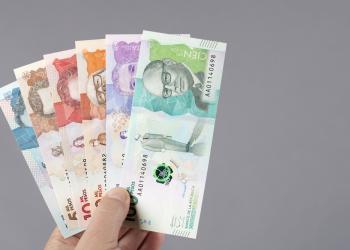 Foto de varios billetes colombianos en la mano de una persona