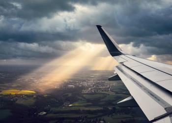 Foto del ala de un avión con un fondo terrestre