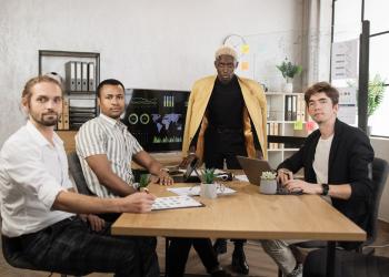 Foto que representa el mercado laboral, cuatro personas sentadas en una mesa